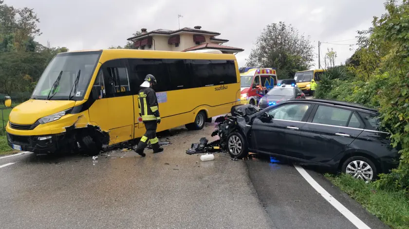 L'intervento dei vigili del fuoco sul luogo dell'incidente a pasiano di pordenone: coinvolti uno scuolabus e una vettura (foto Brisotto / Petrussi)