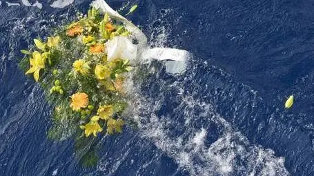 A picture taken on October 5, 2013 shows a bunch of flowers floating in the sea near the Lampedusa harbour after a boat with migrants sank killing more than a hundred of people. ANSA/STRINGER