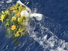 A picture taken on October 5, 2013 shows a bunch of flowers floating in the sea near the Lampedusa harbour after a boat with migrants sank killing more than a hundred of people. ANSA/STRINGER