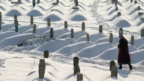 February 1994, Sarajevo, Bosnia and Herzegovina --- A woman walks through the area of Sarajevo that was used for the 1984 Winter Olympic Games which now holds the graves of thousands of casualties of the civil war. --- Image by © Chris Rainier/CORBIS