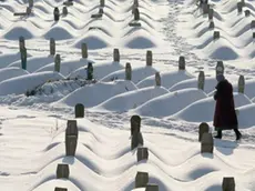 February 1994, Sarajevo, Bosnia and Herzegovina --- A woman walks through the area of Sarajevo that was used for the 1984 Winter Olympic Games which now holds the graves of thousands of casualties of the civil war. --- Image by © Chris Rainier/CORBIS