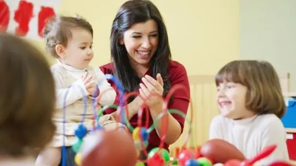 Bambini giocano con la maestra in un asilo nido