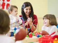 Bambini giocano con la maestra in un asilo nido