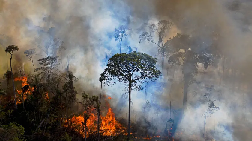 (FILES) In this file photo taken on August 15, 2020, smoke rises from an illegally lit fire in Amazon rainforest reserve, south of Novo Progresso in Para state, Brazil. - A coalition of 230 environmental organisations and Brazilian agribusiness companies wants the country to regain its leadership in combating climate change and called on Jair Bolsonaro's government to present "more ambitious" goals at the next world climate summit on 22-23 April, 2021. (Photo by CARL DE SOUZA / AFP)