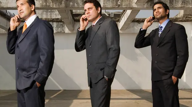 Businessmen Using Cell Phones in Empty Building --- Image by © Ken Seet/Corbis