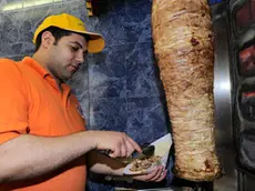 20090422 - MILANO - POL - KEBAB: SARACINESCHE CHIUSE ALL'UNA DI NOTTE IN LOMBARDIA. Un rosticcere turco prepara un kebab oggi a Milano. Kebab, pasticcerie, gelaterie artigianali, pizzerie da asporto in Lombardia dovranno chiudere i battenti all'una di notte e non piu' tardi, salvo deroghe decise dai singoli Comuni: una decisione - presa ieri con l'approvazione di una legge in Consiglio regionale - che fa discutere. ANSA/DANIEL DAL ZENNARO/DRN