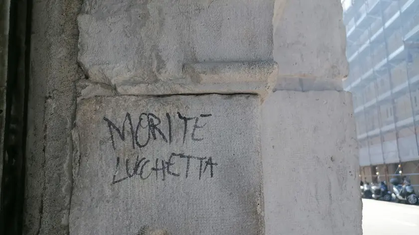 Una delle scritte minatorie apparse sul muro del Centro Luchetta