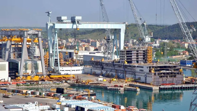 A sinistra, lo stabilimento di Fincantieri, a destra in alto l’ingresso della Nidec e sopra il tavolo con Cisint e Garritani assieme ai delegati delle due aziende
