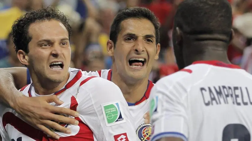 Marco Urena of Costa Rica (L) celebrates with teammates Celso Borges (C) and Joel Campbell after scoring the 3-1 during the FIFA World Cup 2014 group C preliminary round match between Colombia and Greece at the Estadio Mineirao in Belo Horizonte, Brazil, 14 June 2014. (RESTRICTIONS APPLY: Editorial Use Only, not used in association with any commercial entity - Images must not be used in any form of alert service or push service of any kind including via mobile alert services, downloads to mobile devices or MMS messaging - Images must appear as still images and must not emulate match action video footage - No alteration is made to, and no text or image is superimposed over, any published image which: (a) intentionally obscures or removes a sponsor identification image; or (b) adds or overlays the commercial identification of any third party which is not officially associated with the FIFA World Cup) ANSA/JULIO MUNOZ EDITORIAL USE ONLY