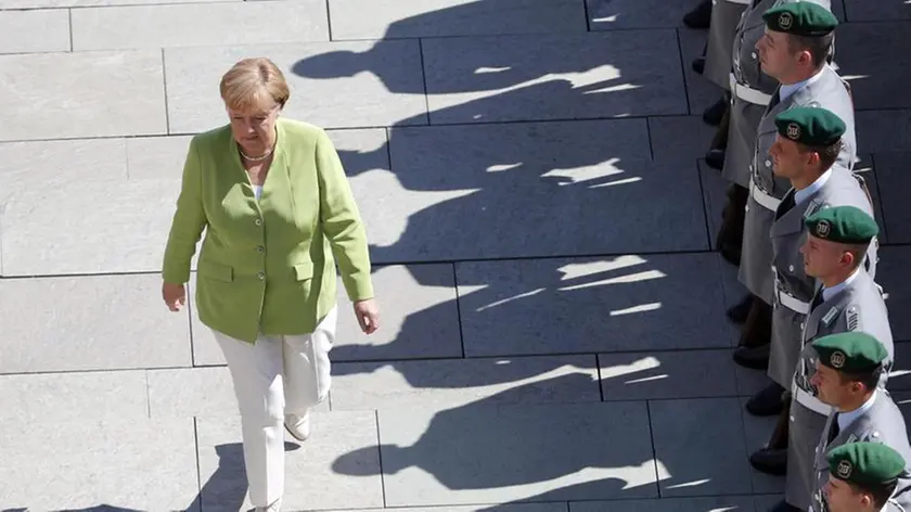 epa06947690 German Chancellor Angela Merkel walks past a line of soldiers (R) ahead of the arrival of Denis Zvizdic, President of the Council of Ministers of Bosnia and Herzegovina, at the Chancellery in Berlin, Germany, 13 August 2018. The two leaders met on the day to discuss bilateral ties. EPA/FELIPE TRUEBA