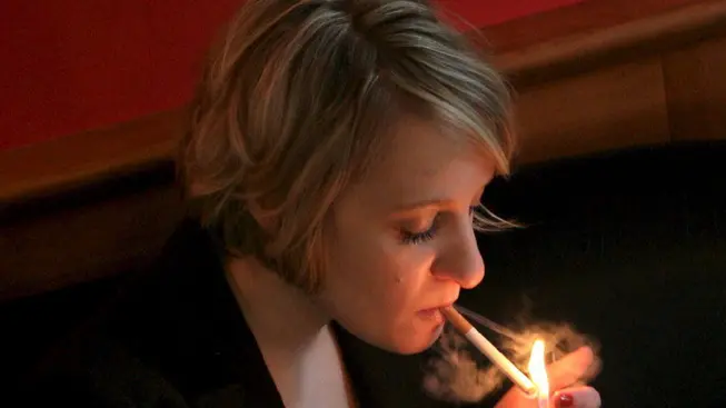 epa01211990 Picture made available 01 January 2008 shows a young woman lights a cigarette in a coffee house in Berlin, Germany, 31 December 2007. Smoking ban in bars and restaurants become effective from 01 January 2008 on in the German city state of Berlin and seven more federal states. Overall, eleven of 16 federal states have now a smoking ban installed. ANSA/ EPA/KLAUS-DIETMAR GABBERT DC