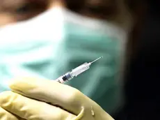 Un medico si prepara a somministrare un vaccino antiinfluenzale