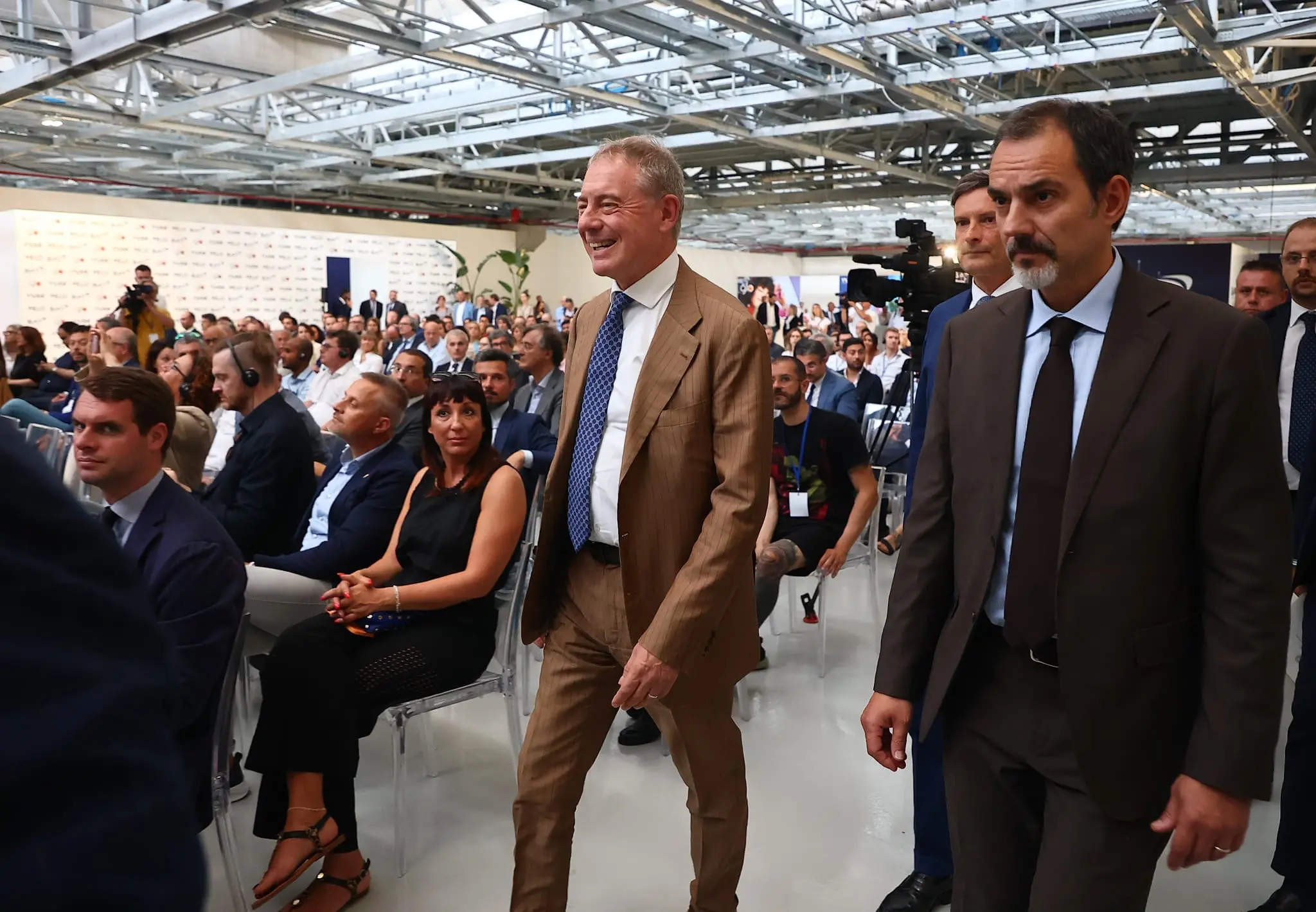 Il ministro Urso arriva in platea all'inaugurazione dello stabilimento Bat Trieste. Foto Lasorte