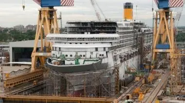Giuseppe Bono a destra con Corrado Antonini presidente di Fincantieri A fianco una nave in costruzione a Fincantieri