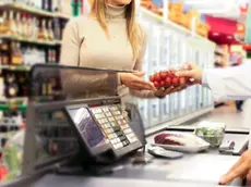 Una cliente alla cassa di un supermercato
