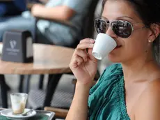 Una ragazza beve una tazzina di caffè