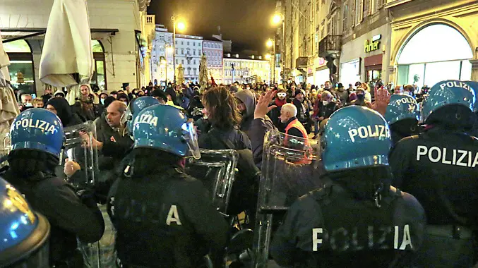 Il fronteggiamento tra le forze dell’ordine, che sfocerà con gli scontri in piazza della Borsa, e una manifestante salita su una sedia Foto Andrea Lasorte