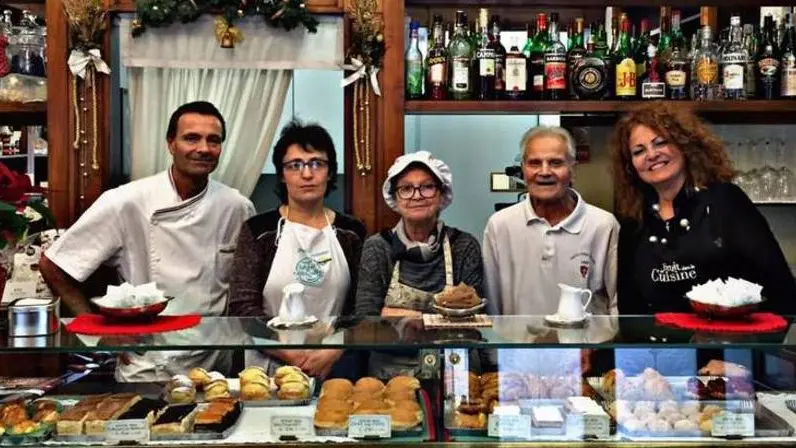 Adriano De Marchi con l’intera famiglia dietro il bancone del Caffè Pasticceria Pirona