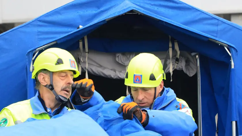 Volontari della Protezione civile di Gorizia mentre montano un tendone Foto Bumbaca