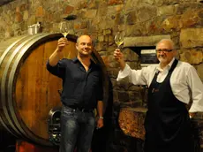 Beniamino Zidarich (a sinistra) con un bicchiere di vino nelle cantine dell'azienda a Prepotto