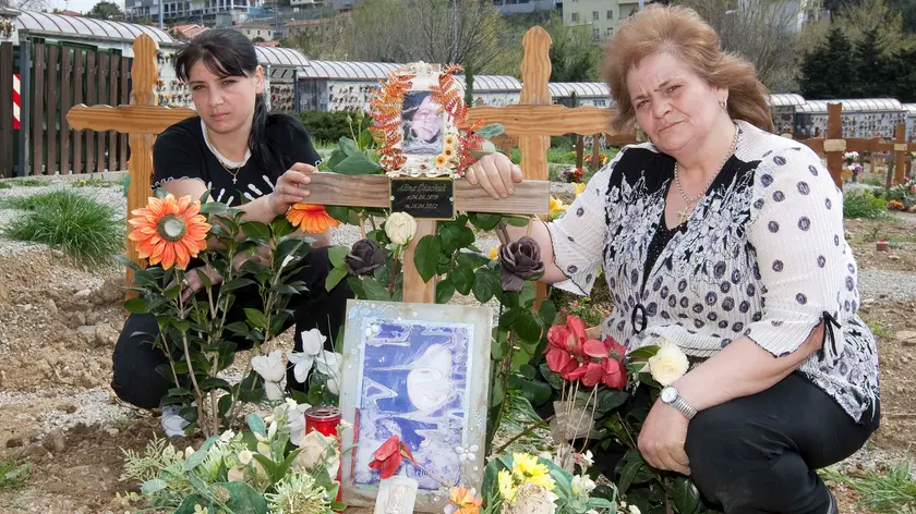 La sorella e la madre di Alina Bonar Diachiuk sulla tomba della giovane, a Sant'Anna