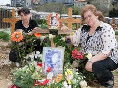 La sorella e la madre di Alina Bonar Diachiuk sulla tomba della giovane, a Sant'Anna