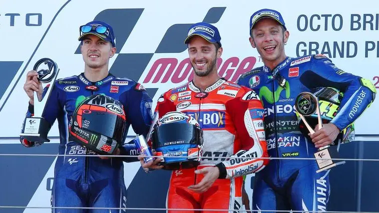 epa06166895 (l to r) Spanish Moto GP rider Maverick Vinales of the Movistar Yamaha MotoGP team (2nd), Italian Moto GP riderAndrea Dovizioso of the Ducati Team (winner) and Italian MotoGP rider Valentino Rossi of the Movistar Yamaha MotoGP team (3rd) on the podium during the MotoGP race of the 2017 British Motorcycling Grand Prix at the Silverstone race track, Northampton, Britain, 27 August 2017. EPA/TIM KEETON
