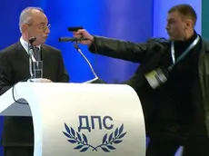 epa03544261 A still grab from a broadcast by Bulgarian television channel BTV handed out by BTV on 19 January 2013 shows an unidentified man (R) pointing a gun at Ahmet Dogan (C), leader of the MRF party of the Turkish minority in Bulgaria, during a party conference in Sofia, Bulgaria, 19 January 2013. The leader of Bulgaria's opposition Movement for Rights and Freedoms escaped an apparent assassination attempt 19 January while addressing a party congress in Sofia, local media reported. The attacker pointed a gun at Dogan, but was prevented from firing, according to the reports. While security wrestled with the attacker, Dogan was tackled to the ground by his bodyguards. The oppositional Movement for Rights and Freedoms (MRF) has deputies in the National Assembly in Sofia and in the EU parliament. EPA/BTV / HANDOUT RECROPPED VERSION OF BTV01 * MANDATORY CREDIT: BTV HANDOUT EDITORIAL USE ONLY/NO SALES