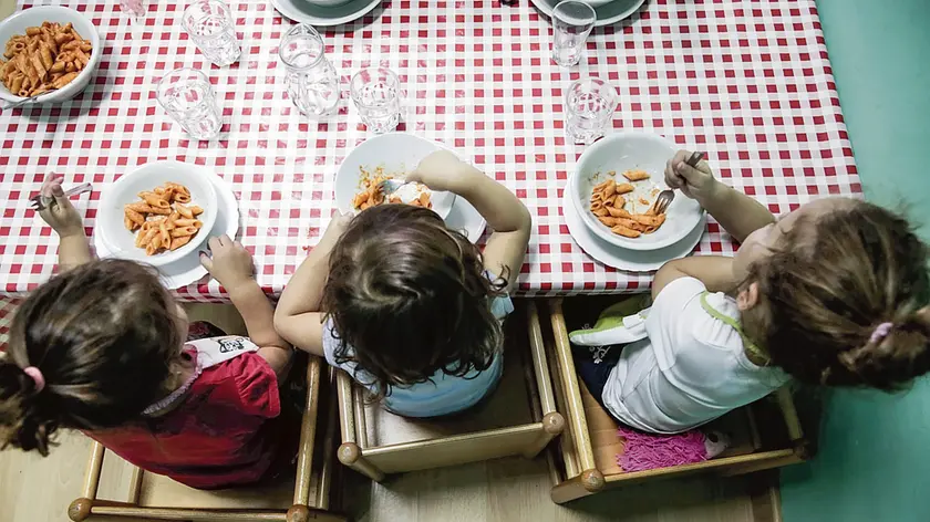 Un gruppetto di bimbi all’asilo durante il momento del pranzo