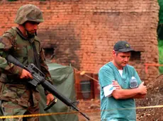 990701-M-5696S-003 U.S. Marines provide security as members of the Royal Canadian Mounted Police Forensics Team investigate a grave site in a village in Kosovo on July 1, 1999. Elements of the 26th Marine Expeditionary Unit are deployed from ships of the USS Kearsarge Amphibious Ready Group as an enabling force for KFOR. KFOR is the NATO-led, international military force which will deploy into Kosovo on a peacekeeping mission known as Operation Joint Guardian. KFOR will ultimately consist of over 50,000 troops from more than 24 contributing nations, including NATO member-states, Partnership for Peace nations and others. DoD photo by Sgt. Craig J. Shell, U.S. Marine Corps. (Released)