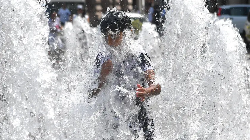 A child cools himself off in a fountain in De Ferrari square in Genoa, Italy, 24 July 2018. A heat wave continues to affect many areas of Italy, with temperatures rising to an intraday high of 35 degrees Celcius in Rome. ANSA/LUCA ZENNARO