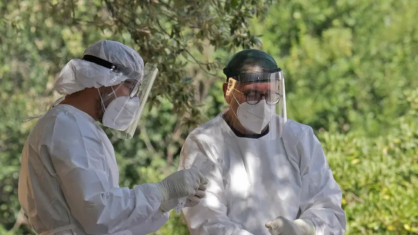 Personale sanitario impegnato nei prelievi per i test: a Trieste il “drive in” dei tamponi è stato allestito nel parco dell’ex Opp Foto Lasorte