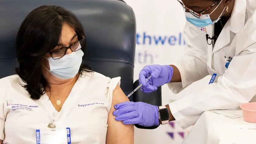 Stephanie Cal (L), a nurse at Long Island Jewish Medical Center, is inoculated with the COVID-19 vaccine by Dr. Michelle Chester (R) in the Queens borough of New York, New York, USA, 14 December 2020. The rollout of the Pfizer and BioNTech vaccine, the first to be approved by the Food and Drug Administration, ushers in the biggest vaccination effort in US history. ANSA/JUSTIN LANE