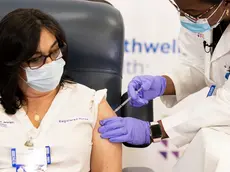 Stephanie Cal (L), a nurse at Long Island Jewish Medical Center, is inoculated with the COVID-19 vaccine by Dr. Michelle Chester (R) in the Queens borough of New York, New York, USA, 14 December 2020. The rollout of the Pfizer and BioNTech vaccine, the first to be approved by the Food and Drug Administration, ushers in the biggest vaccination effort in US history. ANSA/JUSTIN LANE