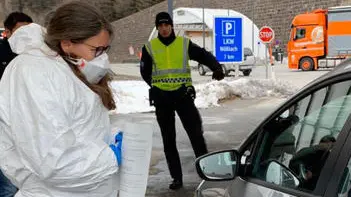 Un medico austriaco in equipaggiamento protettivo controlla la temperatura di un automobilista al passo del Brennero al confine tra l'Austria e l'Italia, in Austria, 10 marzo 2020. Sono iniziati al Brennero i controlli sanitari delle autorità austriache, annunciati nei giorni scorsi dal cancelliere Sebastian Kurz. La polizia austriaca ferma veicoli, ANSA/ STEFANO WALLSICH