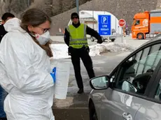 Un medico austriaco in equipaggiamento protettivo controlla la temperatura di un automobilista al passo del Brennero al confine tra l'Austria e l'Italia, in Austria, 10 marzo 2020. Sono iniziati al Brennero i controlli sanitari delle autorità austriache, annunciati nei giorni scorsi dal cancelliere Sebastian Kurz. La polizia austriaca ferma veicoli, ANSA/ STEFANO WALLSICH