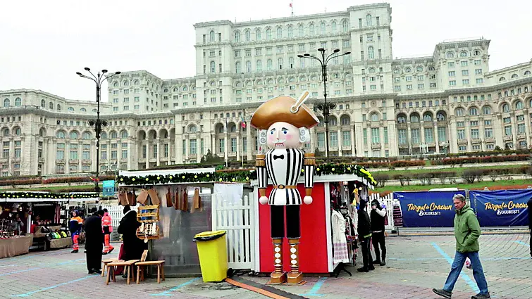 Un mercatino natalizio a Bucarest, davanti al palazzo che ospita il Parlamento della Romania