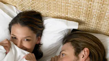 Young Couple in Bed --- Image by © Vincent Mo/Corbis