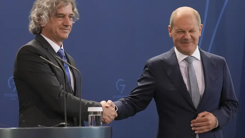 inge la mano al cancelliere tedesco Olaf Scholz