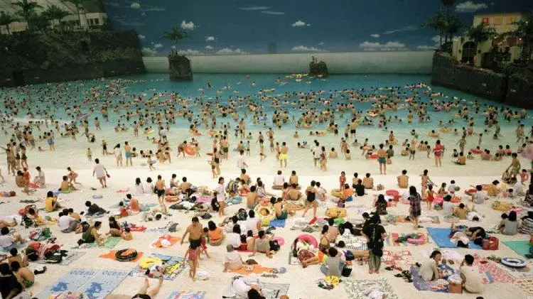 Japan. Miyazaki. The Artificial beach inside the Ocean Dome. From 'Small World'. 1996. Images for use only in connection with direct publicity for the exhibition "Life's a beach" by Martin Parr presented at Museo Revoltella, Trieste, Italy from October 27th, 2019 to January 6th, 2020. These images are for one time non-exclusive use only and must not be electronically stored in any media asset retrieval database · Images must be credited and captioned as outlined by Magnum Photos · Images must not be reproduced online at more than 1000 pixels without permission from Magnum Photos · Images must not be overlaid with text, cropped or altered in any way without permission from Magnum Photos.