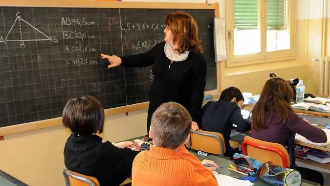 Un'insegnante alla lavagna durante una lezione in classe