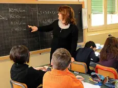 Un'insegnante alla lavagna durante una lezione in classe