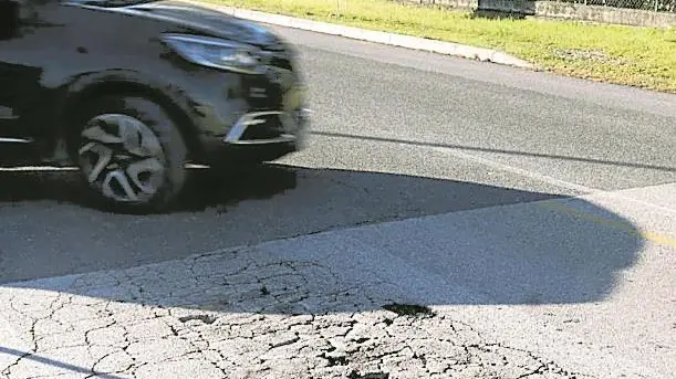 Asfalto in frantumi in via Terza Armata