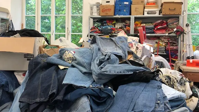 La pila di vecchi jeans donati dai cittadini alla sartoria Lister dopo l’appello del suo presidente Pino Rosati