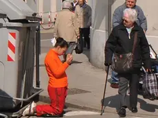 Una ragazza mentre chiede l'elemosina