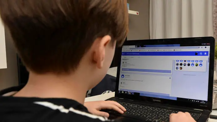 Un giovane studente della Scuola Elementare Renzo Pezzani di Milano svolge alcuni compiti online organizzati dall'insegnante dopo la chiusura delel scuole a causa dell'emergenza coronavirus. Ansa/Andrea Fasani