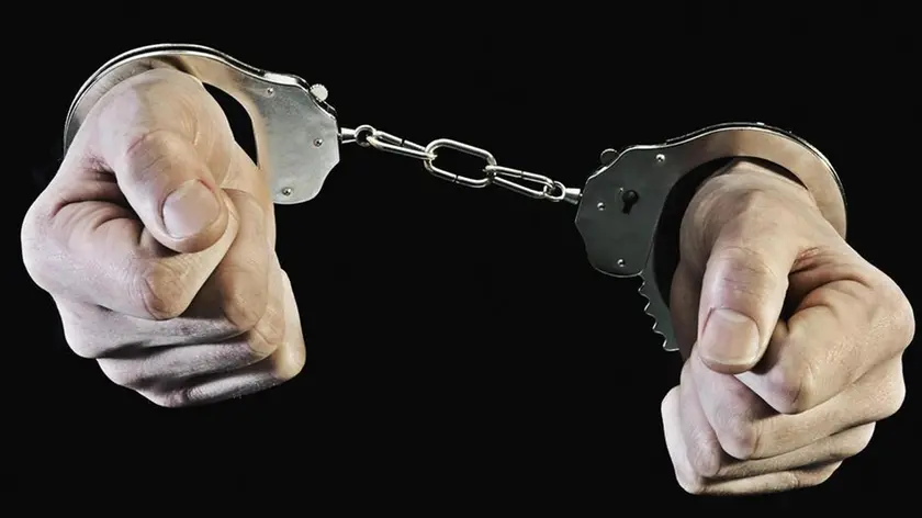 Hands in handcuffs --- Image by © Tara Moore/Corbis