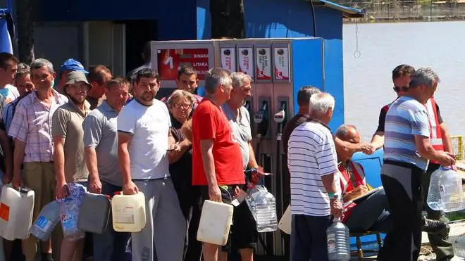 epa04219417 People wait in line to get drinkable water in Obrenovac, Serbia, 22 May 2014. A state of emergency has been declared in Serbia due to severe floods caused by rain falling for more than 48 hours. Thousands of people in Bosnia, Serbia and Croatia were evacuated as rising floodwaters swallowed homes and farmland after last week's record rains. EPA/KOCA SULEJMANOVIC