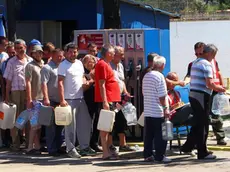 epa04219417 People wait in line to get drinkable water in Obrenovac, Serbia, 22 May 2014. A state of emergency has been declared in Serbia due to severe floods caused by rain falling for more than 48 hours. Thousands of people in Bosnia, Serbia and Croatia were evacuated as rising floodwaters swallowed homes and farmland after last week's record rains. EPA/KOCA SULEJMANOVIC