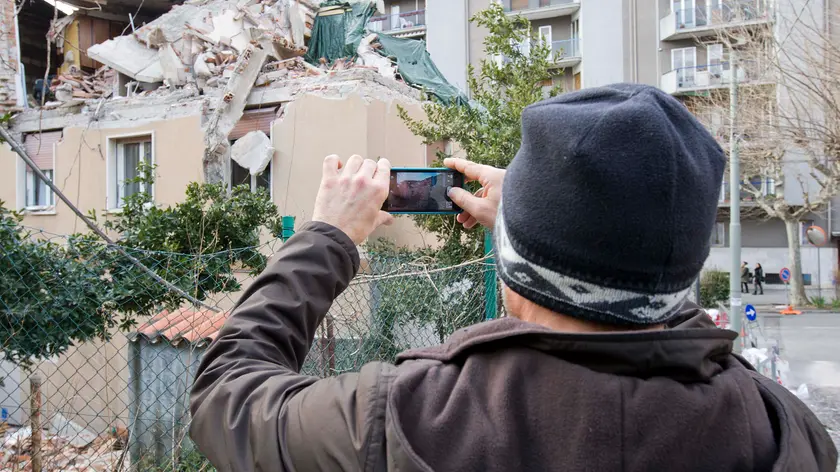 Una persona fotografa la casa devastata di via Baiamonti (Foto Massimo Silvano)